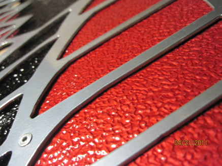 Close up of Pontiac emblem in Super Chrome, Ink Black and Wilder Red over Super Chrome